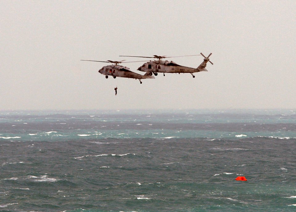 US Navy 071223-N-4403A-086 A Navy Search and Rescue swimmer descends from an MH-60S Seahawk helicopter