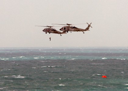 US Navy 071223-N-4403A-086 A Navy Search and Rescue swimmer descends from an MH-60S Seahawk helicopter