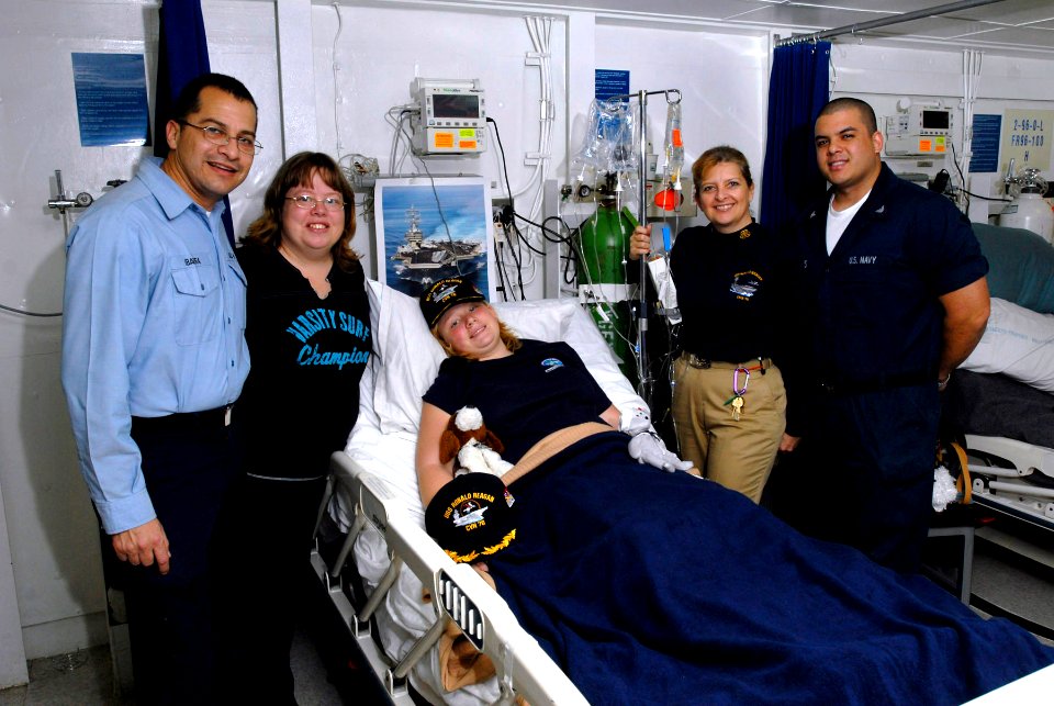 US Navy 071217-N-4776G-001 Laura Montero 14, from Albion, Ill., center, rests comfortably in the medical ward aboard the aircraft carrier USS Ronald Reagan (CVN 76) following an emergency appendectomy