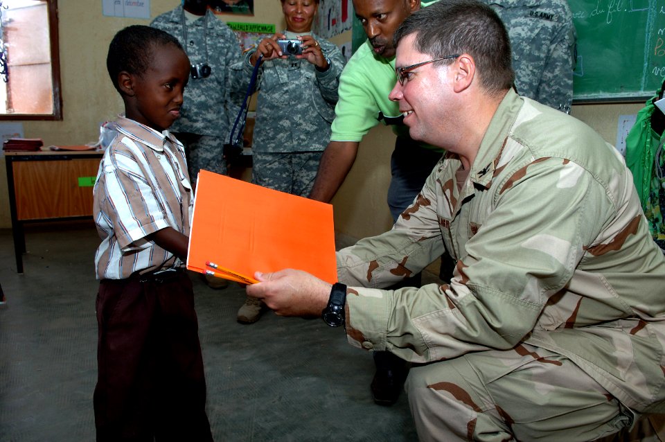 US Navy 071215-N-3931M-101 Capt. Dennis Gallagher from Combined Joint Task Force-Horn of Africa (CJTF-HOA) presents a gift to a local student at a school dedication ceremony in Ali Adde