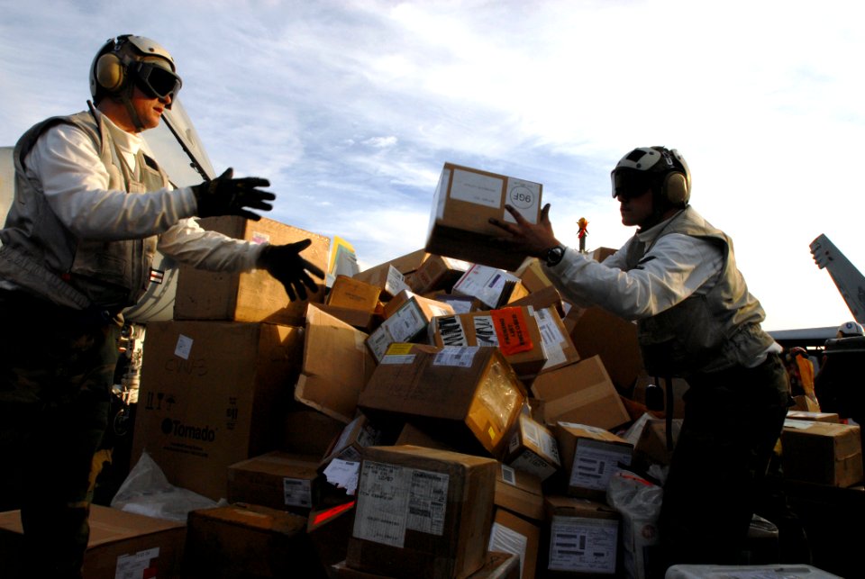 US Navy 071218-N-1688B-443 Sailors move mail on the flight deck of the Nimitz-class nuclear-powered aircraft carrier USS Harry S. Truman (CVN 75) for waiting crewmembers