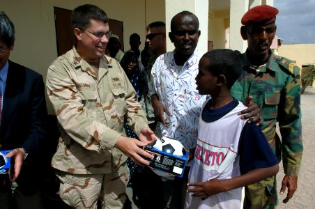 US Navy 071215-N-3931M-054 Capt. Dennis Gallagher from Combined Joint Task Force-Horn of Africa (CJTF-HOA) presents a gift to a local student at a school dedication ceremony in Ali Adde