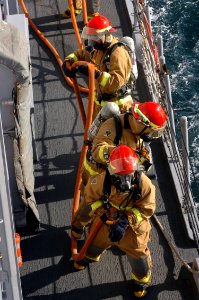 US Navy 071219-N-1831S-061 During a general quarters drill crewmembers aboard the guided-missile frigate USS Carr (FFG 52) charge the hoses as they head towards the fire