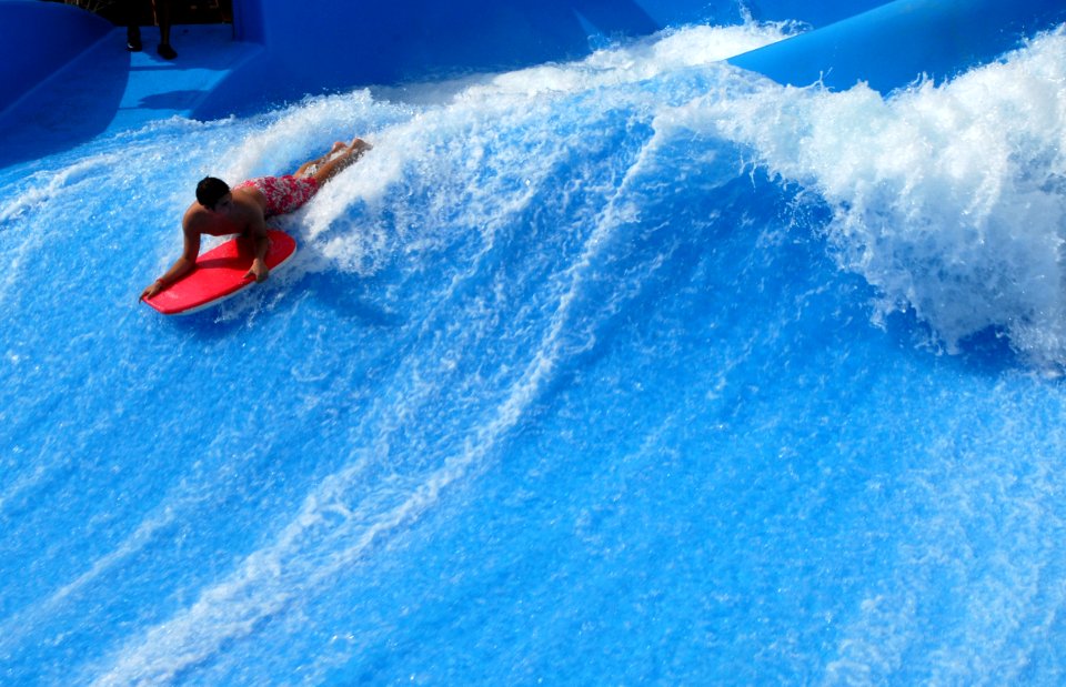 US Navy 071227-N-1688B-148 A Sailor attached to the Nimitz-class aircraft carrier USS Harry S. Truman (CVN 75) surfs an artificial wave pool during a USO water park tour during a port visit in the Middle East