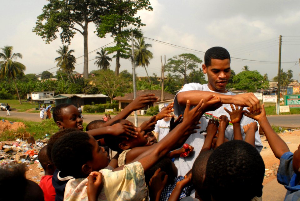 US Navy 071226-N-0193M-093 Engineman Fireman Lonnie Davis hands out candy to children in Takoradi, Ghana near Essikado hospital where Africa Partnership Station (APS) volunteers spent the day completing painting projects