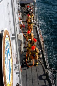 US Navy 071219-N-1831S-062 During a general quarters drill aboard the guided-missile frigate USS Carr (FFG 52) crew members charge hoses while approaching a simulated fire