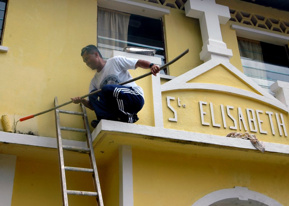 US Navy 071219-N-4014G-090 Storekeeper 2nd Class Tomas Lomotan helps to paint the exterior of the St. Elizabeth Convent and Orphanage during a community Relations Project