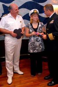 US Navy 080106-N-0555B-012 Laura Montero, center, speaks with Ronald Reagan Commanding Officer Capt. Terry B. Kraft, right, and Dawn Princess Commanding Officer Capt. Marco Fortezze during a luncheon photo