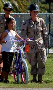 US Navy 071218-N-7367K-009 Builder 3rd Class Taylor Crow, a Seabee attached to Naval Mobile Construction Battalion (NMCB) 1, Guam Det., poses for a photo with a student at Chief Brodie Memorial Elementary School