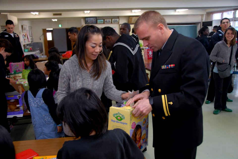 US Navy 071224-N-8594S-066 Lt. j.g. Steven T. Benefield helps open a gift to give to the children at the Shunko-gakuen orphanage