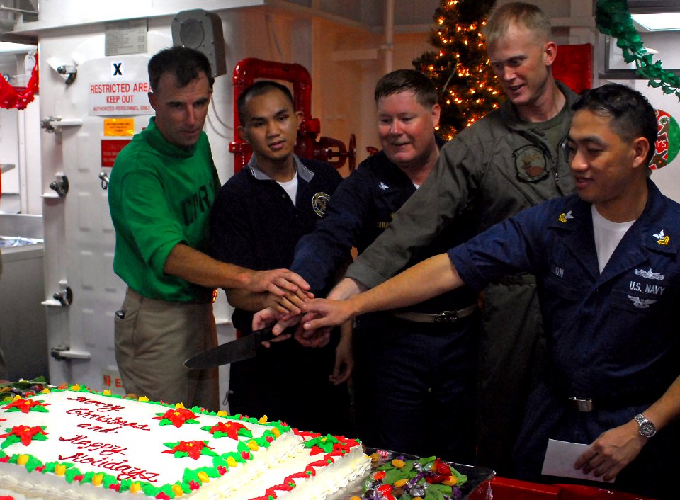 US Navy 071225-N-4774B-046 USS Tarawa (LHA 1), commanding officer, Capt. Donald R. Shunkwiler, center, and fellow Sailors cut a cake during a Christmas Day cake cutting ceremony
