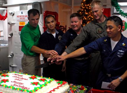 US Navy 071225-N-4774B-046 USS Tarawa (LHA 1), commanding officer, Capt. Donald R. Shunkwiler, center, and fellow Sailors cut a cake during a Christmas Day cake cutting ceremony
