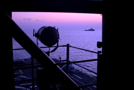 US Navy 071229-N-4774B-014 The amphibious dock landing ship USS Germantown (LSD 42), in the distance, passes the amphibious assault ship USS Tarawa (LHA 1) as dawn breaks