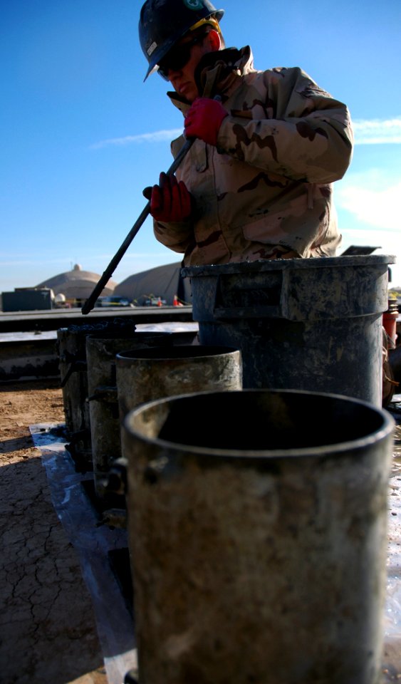 US Navy 080108-N-7367K-004 Engineering Aide 2nd Class Robert Wetzel, assigned to Naval Mobile Construction Battalion (NMCB) 1, Task Force Sierra, fills cylinders with concrete in preparation for a compression test