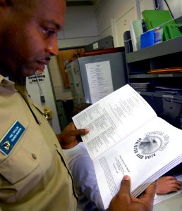 US Navy 080104-N-0455L-002 Chief Yeoman Fredrick Taylor Checks the guide lines for voting assistance, aboard the Nimitz-class nuclear-powered aircraft carrier USS Harry S. Truman (CVN 75)