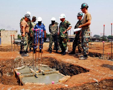 US Navy 080102-N-8933S-045 Builder 2nd Class Ulises Arias shows Capt. John B. Nowell Jr., Commodore, Africa Partnership Station (APS) and Ghanaian Navy Officers the progress made on the hospital being built by U.S. Navy Seabees