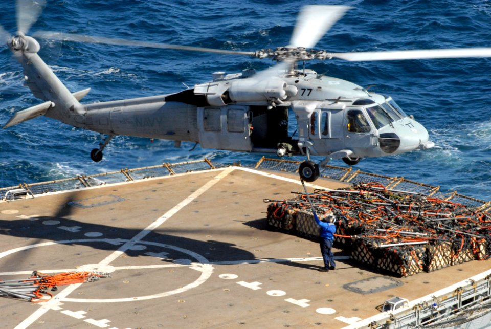 US Navy 080109-N-0640K-002 A Sailor assigned to the Military Sealift Command ammunition ship USNS Flint (T-AE 32) attaches a sling to an MH-60S Seahawk helicopter