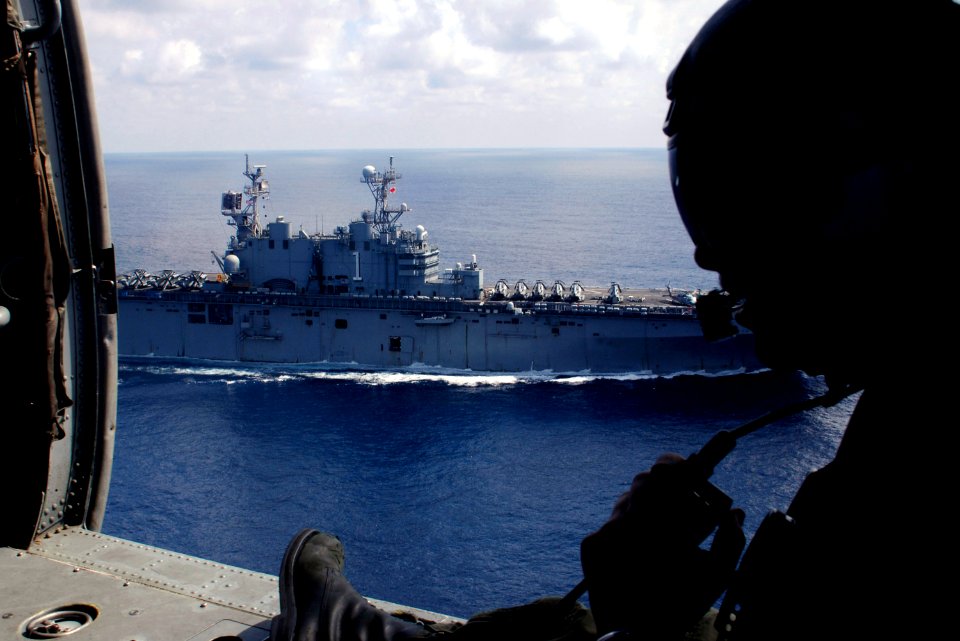 US Navy 071222-N-6597H-080 Aviation Warfare Systems Operator 3rd class Deric Parsoneault, a search and rescue swimmer, communicates with the pilot of an MH-60S