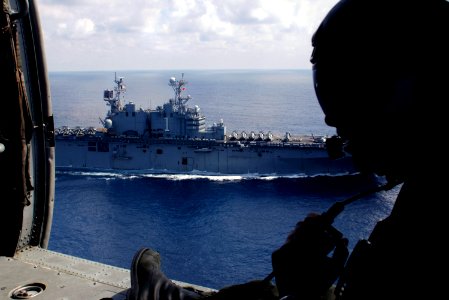 US Navy 071222-N-6597H-080 Aviation Warfare Systems Operator 3rd class Deric Parsoneault, a search and rescue swimmer, communicates with the pilot of an MH-60S