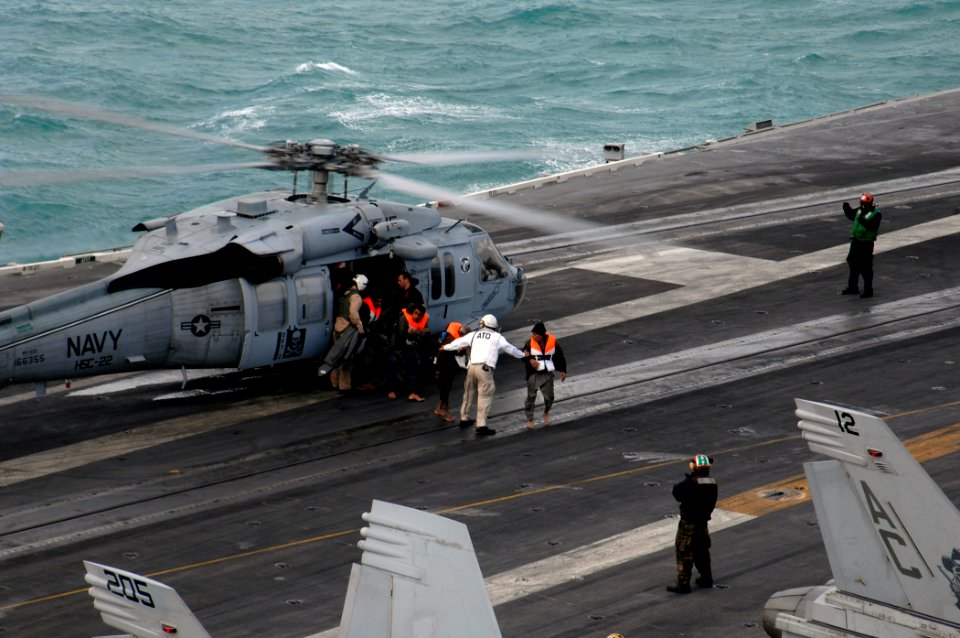 US Navy 071223-N-1688B-089 Shipwrecked survivors are escorted across the flight deck of the Nimitz-class nuclear-powered aircraft carrier USS Harry S. Truman (CVN 75) after being rescued at sea by two MH-60S Seahawk helicopters