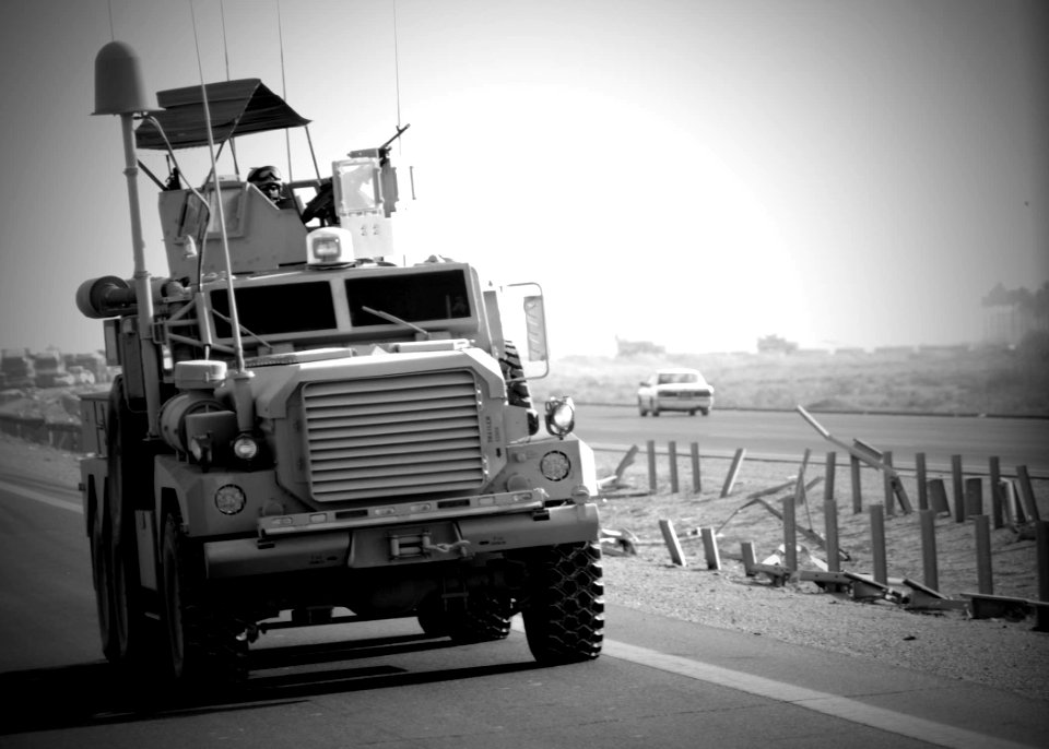 US Navy 080104-N-3857R-002 A Seabee assigned to Naval Mobile Construction Battalion (NMCB) 1 mans his M240B machine gun in the vehicle turret as part of a convoy security element