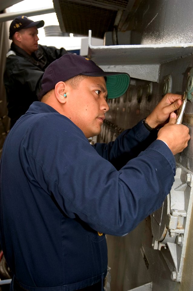 US Navy 080109-N-9520G-002 Electrician's Mate 1st Class Romy Dacuba replaces burnt out shore power receptacle indicating lights during Arleigh Burke-class guided-missile destroyer USS John S. McCain's (DDG 56) upkeep period