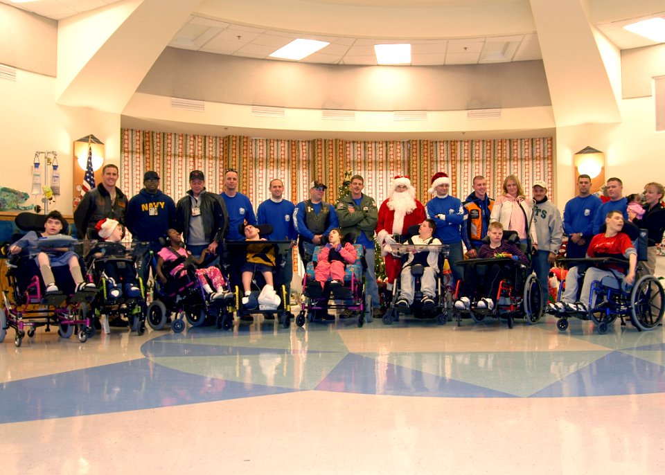 US Navy 071226-N-4669J-039 Santa and members of the motorcycle safety group of Strike Fighter Squadron (VFA) 143, pose for a group shot with several children at St. Mary's Home for Disabled Children
