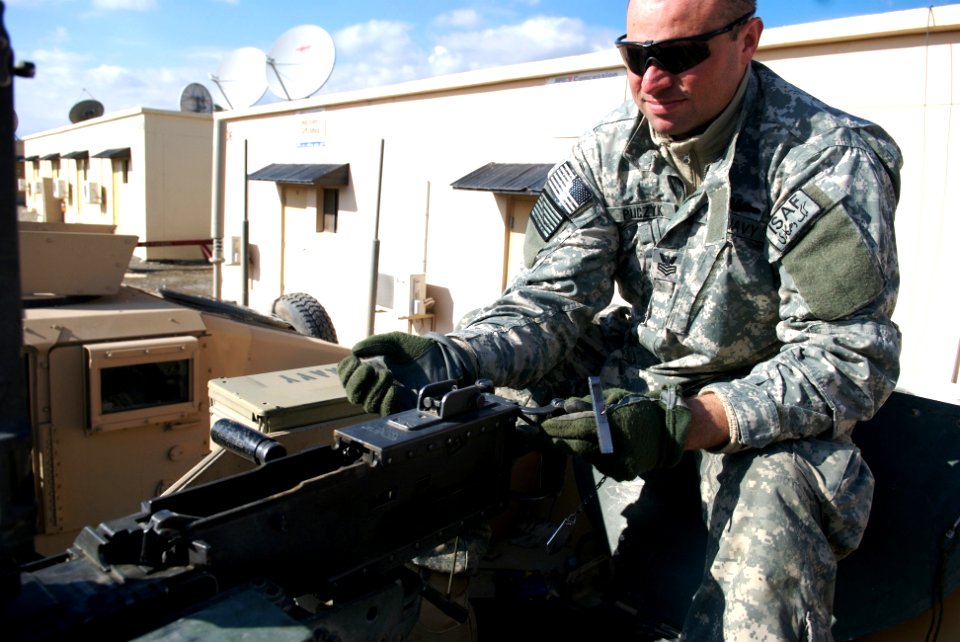 US Navy 080106-N-3385W-035 Culinary Specialist 1st Class Oliver Puckyk sets the head space and timing on the .50-cal machine gun prior to a recent convoy to conduct quality assurance of road construction in and around Khost pro