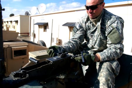 US Navy 080106-N-3385W-035 Culinary Specialist 1st Class Oliver Puckyk sets the head space and timing on the .50-cal machine gun prior to a recent convoy to conduct quality assurance of road construction in and around Khost pro