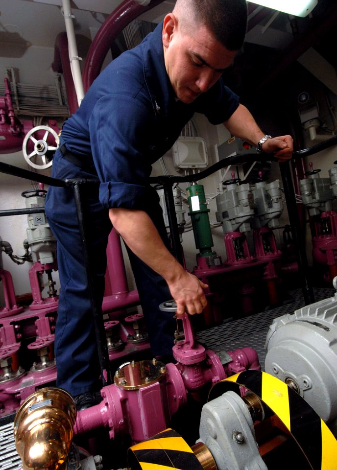 US Navy 080106-N-8923M-006 Aviation Boatswain's Mate Fuel 3rd Class Matthew L. Fox opens a JP-5 fuel tank releasing free water from a storage tank in pump room 3