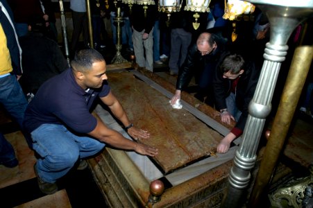 US Navy 080103-N-7955L-108 Sailors and Marines from the amphibious assault ship USS Kearsarge (LHD 3) touch the anointing stone of Jesus Christ in the Church of the Holy Sepulcher in Jerusalem during a recent tour