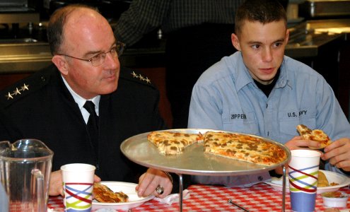 US Navy 080110-N-8848T-007 Vice Adm. John C. Harvey Jr., left, Chief of Naval Personnel, shares a pizza with Seaman Recruit Kolby Zipperer