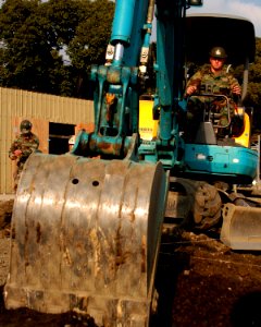 US Navy 080104-N-0807W-004 Equipment Operator 2nd Class Derek Perez, assigned to Naval Mobile Construction Battalion (NMCB) 5, Detachment Sasebo, operates a backhoe to shift soil into a foundation site before laying concrete
