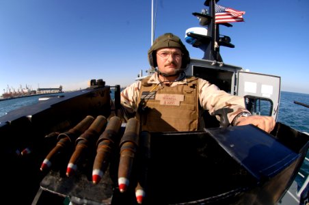 US Navy 080108-N-7027P-009 Boatswain's Mate 1st Class Jay Burnell, assigned to NCWRON-21, mans a .50-cal machine gun as his unit provides security and patrols Shuaybah Port for suspicious activity as the dock landing ship USS G