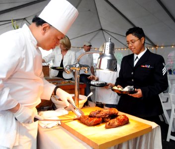 US Navy 080112-N-1722M-002 Bacara chef, Roger Riofirr slices some tri-tip steak and pork for Seaman Kristi Romero assigned to the Nimitz-class nuclear-powered aircraft carrier USS Ronald Reagan (CVN 76), at the parking lot of G photo