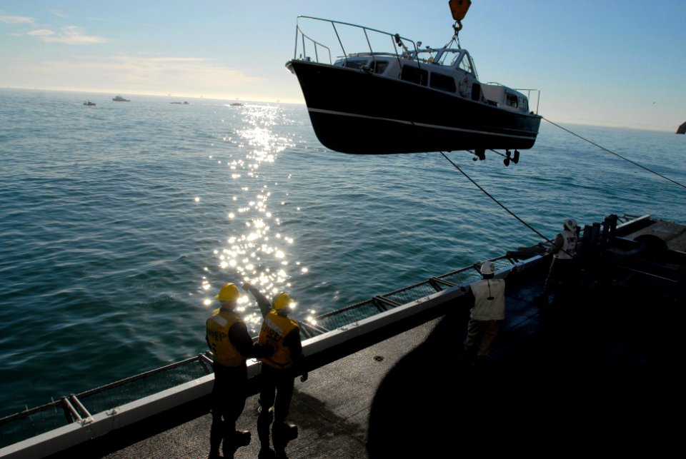 US Navy 080111-N-4009P-459 Boatswain's mates work to crane off the admiral's barge from the hangar bay into the water