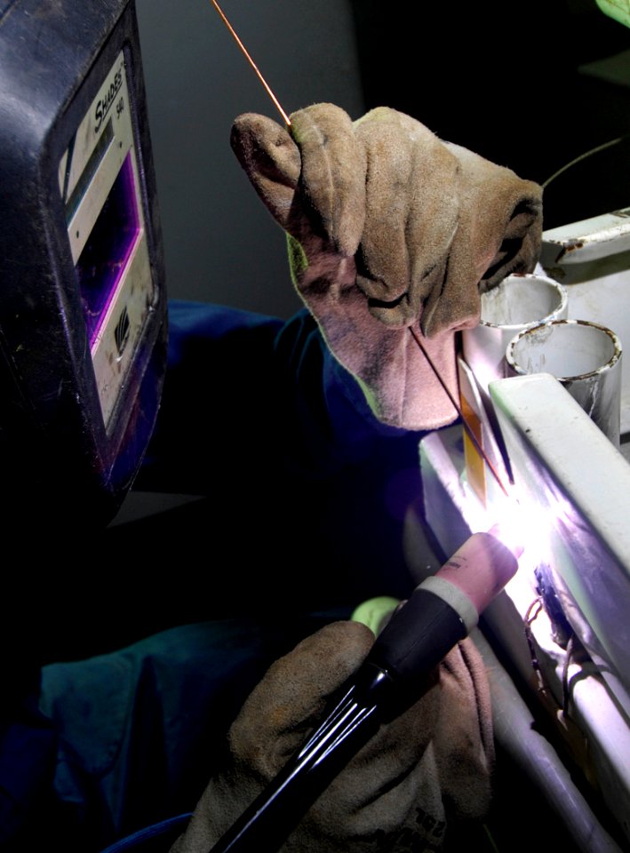 US Navy 080108-N-0455L-001 Aviation Structural Mechanic 2nd Class Jason Knapp performs a tig weld on a B1 stand aboard the aircraft carrier USS Harry S. Truman (CVN 75)