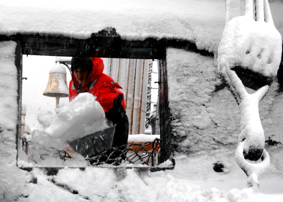 US Navy 080114-N-2893B-001 Seaman Nicole Davis shovels snow through a gun port aboard USS Constitution
