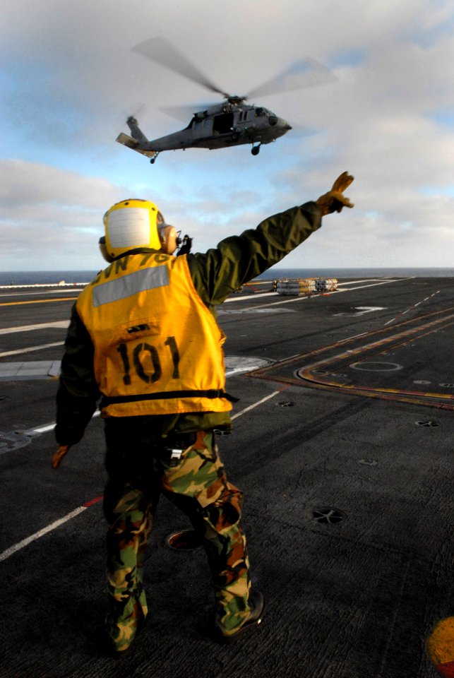 US Navy 080109-N-0640K-005 Aviation Boatswain's Mate (Handling) 3rd Class Alexis Fernandez directs an MH-60S Seahawk helicopter, assigned to the