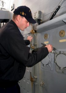 US Navy 080109-N-9520G-003 Electrician Mate 1st Class Randy Flowe paints around shore power receptacles during Arleigh Burke-class-guided-missile destroyer USS John S. McCain's (DDG 56) upkeep period at Commander, Fleet Activit