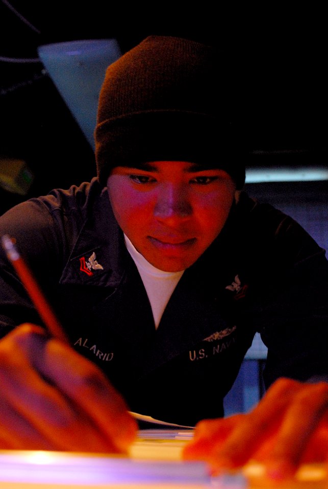 US Navy 080110-N-7526R-645 Operations Specialist 2nd Class Sergio Alarid makes a plot on a digital dead reckoning tracer (DDRT) while standing watch in sea combat aboard the Nimitz-class nuclear-powered aircraft carrier USS Ron