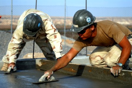 US Navy 080112-N-0260R-020 Builder 2nd Class Johan Sanchez and Steel Worker 3rd Class Andrew Heffron, both assigned to Naval Mobile Construction Battalion (NMCB) 40, level concrete at a construction site in Obock photo