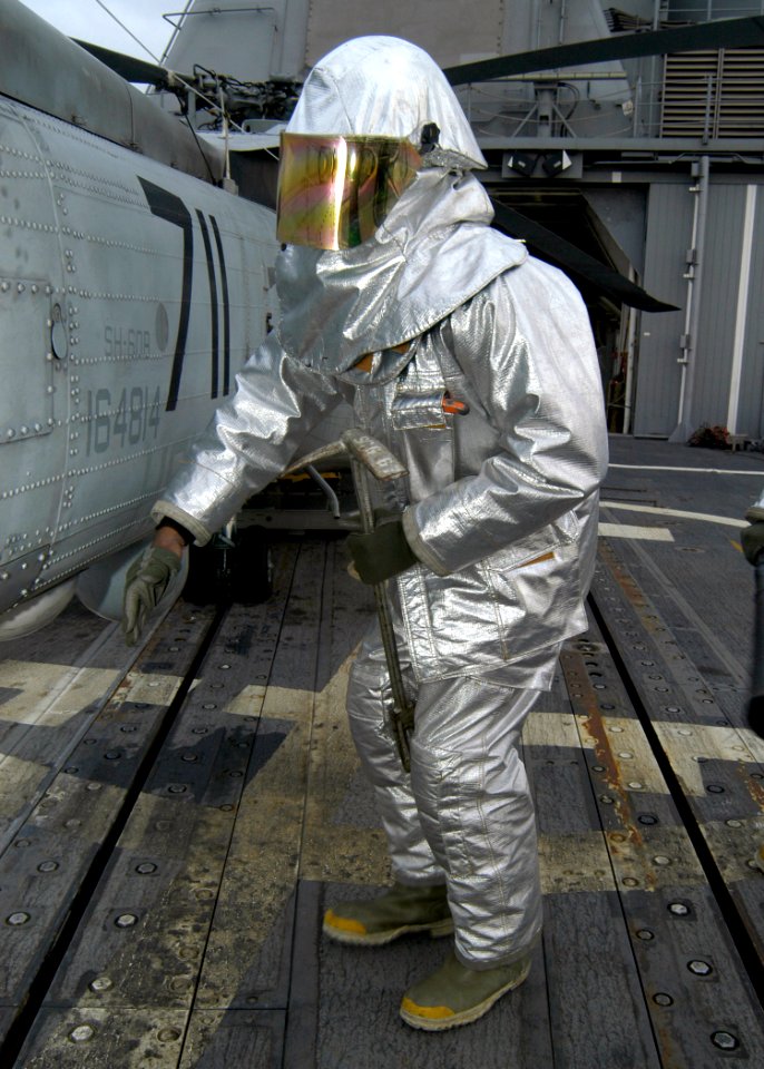 US Navy 080118-N-4649C-033 A Sailor wearing a fire-retardant suit checks for hot spots during a crash and smash drill aboard the guided-missile cruiser USS Shiloh (CG 67)