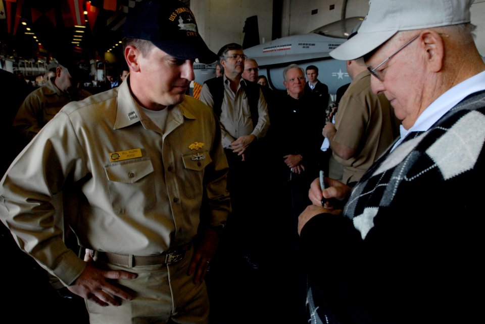 US Navy 080122-N-4776G-031 Professional golfer Billy Casper autographs a golf ball for Lt. Bill Kuzma aboard the Nimitz-class aircraft carrier USS Ronald Reagan (CVN 76)