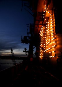 US Navy 080124-N-6538W-002 The island lights of the Nimitz-class aircraft carrier USS John C. Stennis (CVN 74) illuminate the ship as the sun rises over Bremerton