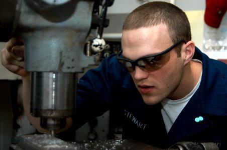 US Navy 080125-N-7955L-053 Machinery Repairman Fireman Keith Stewart uses a drill press to drill a hole in a piece of steel in the machinery repair shop aboard the amphibious assault ship USS Kearsarge (LHD 3)