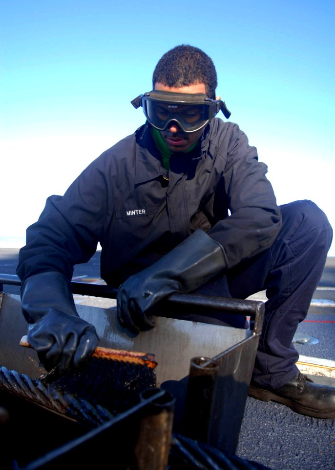 US Navy 080119-N-9079D-056 Aviation Boatswain's Mate (Equipment) Airman Keith T. Minter dry coats an arresting gear wire on the flight deck of the Nimitz-class nuclear-powered aircraft carrier USS Abraham Lincoln (CVN 72)