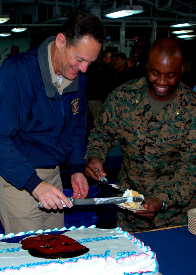 US Navy 080118-N-9421C-023 Capt. Ed Rhoades III, commanding officer of the amphibious assault ship USS Peleliu (LHA 5) and Maj. Donato Powell serve the first slice of cake during a Dr. Martin Luther King Jr. Day celebration abo