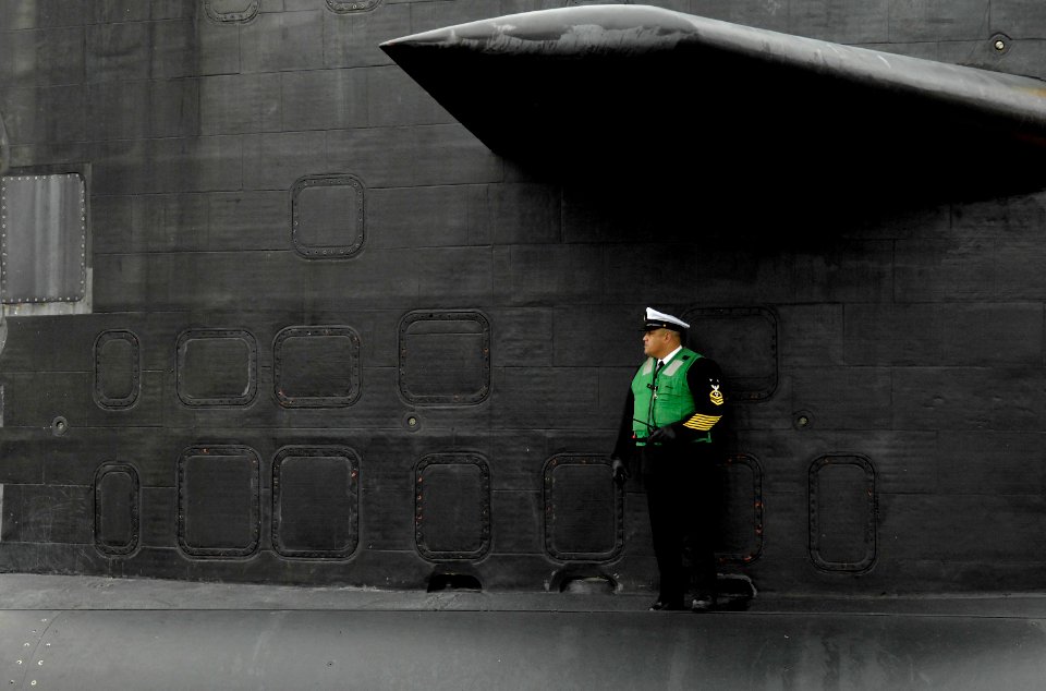 US Navy 080124-N-8467N-002 The fast-attack submarine USS Philadelphia (SSN 690) Chief of the Boat Master Chief Machinist Mate Manny Meneses checks the aft end of the boat as Philadelphia pulls into Submarine Base New London