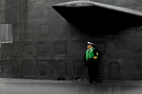 US Navy 080124-N-8467N-002 The fast-attack submarine USS Philadelphia (SSN 690) Chief of the Boat Master Chief Machinist Mate Manny Meneses checks the aft end of the boat as Philadelphia pulls into Submarine Base New London